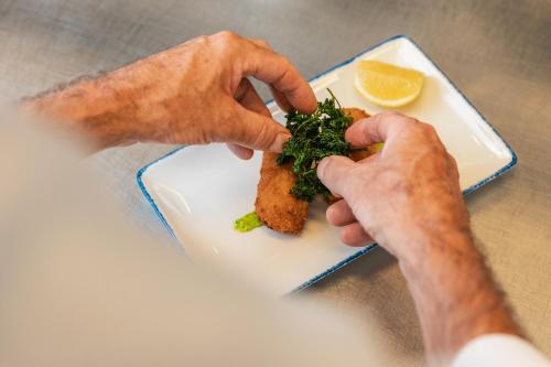 a person eating a piece of food on a plate at De Lindenhoeve Boutique Hotel in Sluis