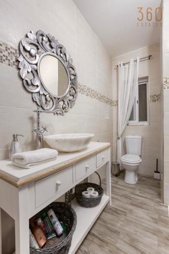 a white bathroom with a sink and a mirror at A beautiful spacious home in a picaresque location by 360 Estates in Hal Ghaxiak