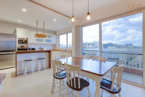 a kitchen with a table and chairs and a large window at A beautiful spacious home in a picaresque location by 360 Estates in Hal Ghaxiak