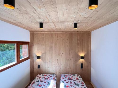 a bedroom with two beds and a wooden wall at Appartement Valloire, 2 pièces, 4 personnes - FR-1-263-189 in Valloire