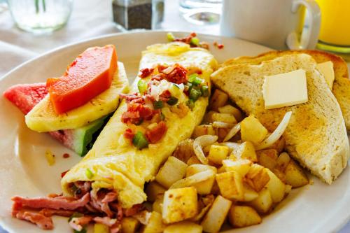 a plate of breakfast food with a sandwich and potatoes at Azure Del Mar in Maya Beach