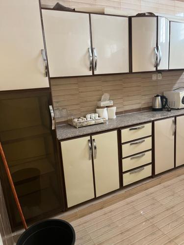 uma cozinha com armários brancos e bancadas cinzentas em النقره خلف العثيم مول 4 em Hail