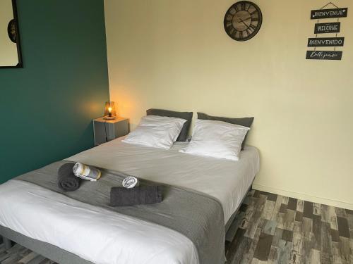 - une chambre dotée d'un lit avec une horloge murale dans l'établissement Studio en Résidence La Baie de l Adon, à Saint-Gilles-Croix-de-Vie