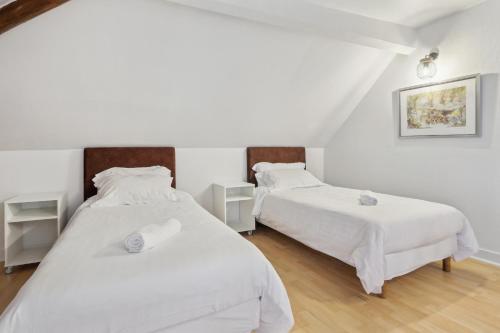 two beds in a room with white walls and wooden floors at Hôtel Robespierre Ex Idéal hôtel Paris - Montreuil in Montreuil