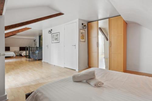 ein Schlafzimmer mit einem weißen Bett und ein Wohnzimmer in der Unterkunft Hôtel Robespierre Ex Idéal hôtel Paris - Montreuil in Montreuil