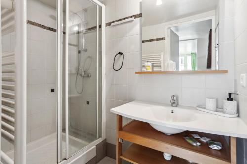 ein Bad mit einem Waschbecken und einer Dusche in der Unterkunft Hôtel Robespierre Ex Idéal hôtel Paris - Montreuil in Montreuil