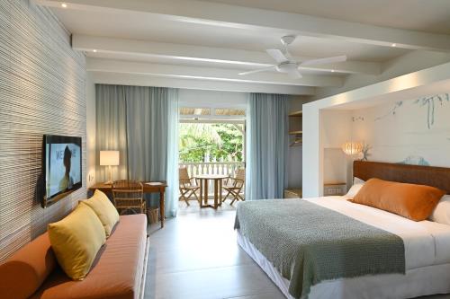 um quarto de hotel com uma cama e um sofá em Veranda Grand Baie Hotel & Spa em Grand Baie