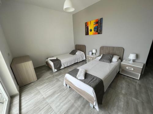 Un dormitorio con dos camas y dos mesitas de noche. en F8 Room 3, Private Room two single beds shared bathroom in shared Flat, en Msida