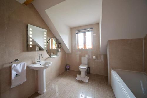 a bathroom with a sink and a toilet and a tub at Beech Tree Eco Lodge in Brecon