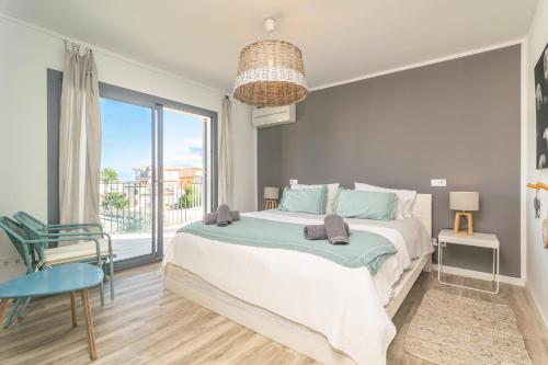 a bedroom with a large bed and a large window at Casa del Mar in Son Serra de Marina