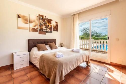 a bedroom with a bed and a large window at Can Pedra junto a Playa den Bossa in Sant Jordi