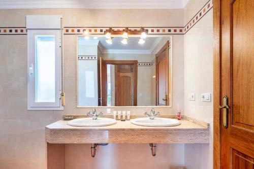 a bathroom with two sinks and a large mirror at Can Pedra junto a Playa den Bossa in Sant Jordi