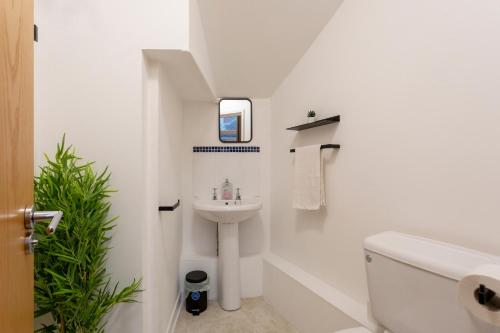 a white bathroom with a sink and a toilet at Oxford Row Apartments, Leeds City Centre in Leeds