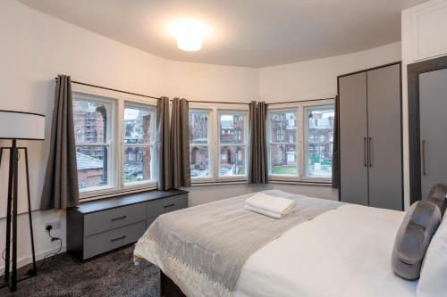a bedroom with a bed and some windows at Oxford Row Apartments, Leeds City Centre in Leeds