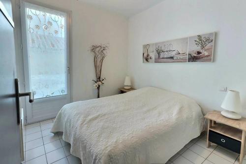 une chambre blanche avec un lit et une fenêtre dans l'établissement Cont, à Valras-Plage