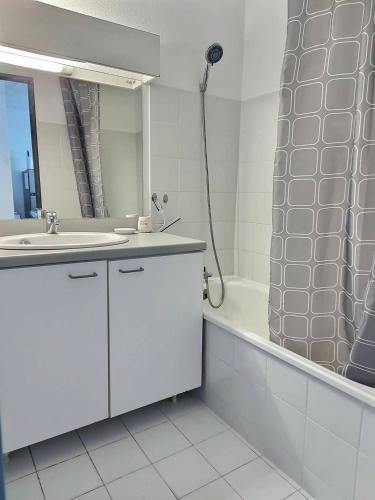 une salle de bain blanche avec un lavabo et une douche dans l'établissement Cont, à Valras-Plage