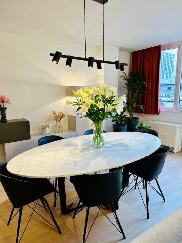 a dining room table with a vase of flowers on it at Urbanstay Suites Grand Place Luxury Apartment in Brussels