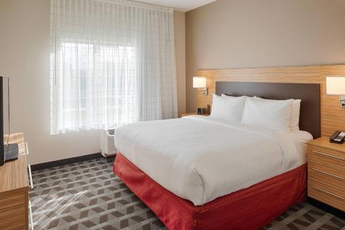 a hotel room with a large bed and a window at TownePlace Suites Columbus Hilliard in Hilliard