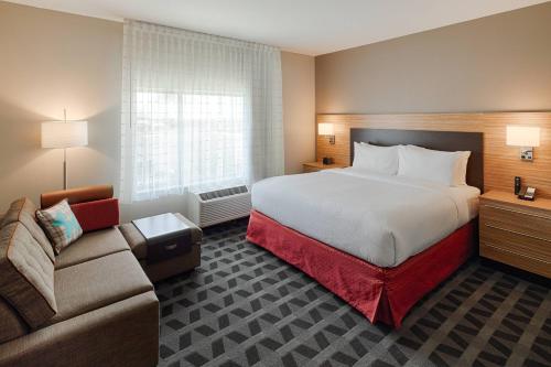 TownePlace Suites Columbus Hilliard في هيليارد: غرفه فندقيه بسرير واريكه