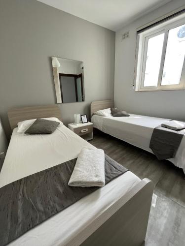 a bedroom with two beds and a mirror at F9-2 Room 2 single beds shared bathroom in shared Flat in Msida