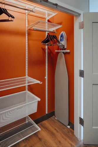 a closet with an orange wall and a paddle in it at TownePlace Suites Columbus Hilliard in Hilliard