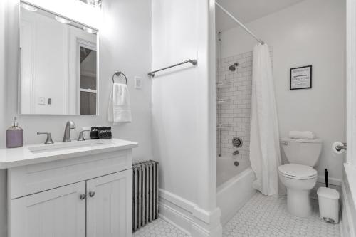 biała łazienka z toaletą i prysznicem w obiekcie Spacious Second Empire Suite at The Platt Mansion w mieście Buffalo