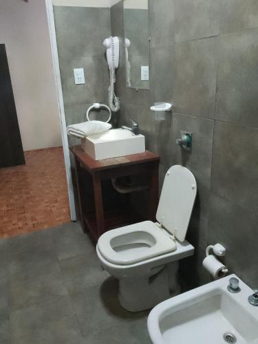 a bathroom with a toilet and a sink and a phone at Cabañas Eluney in Villa Parque Siquiman