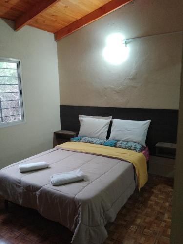 1 dormitorio con 1 cama con 2 toallas en Cabañas Eluney in 