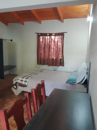 a bedroom with a bed and a table and chairs at Cabañas Eluney in Villa Parque Siquiman