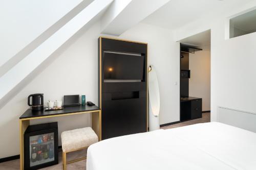 a bedroom with a bed and a tv and a fireplace at elaya hotel vienna city center in Vienna