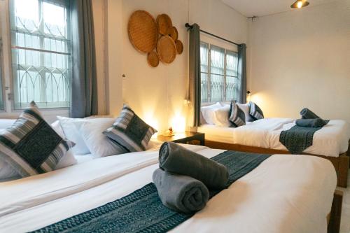 清邁的住宿－Baan Ragang : Cozy Entire House in Old Chiang Mai，带三张床和两扇窗户的房间