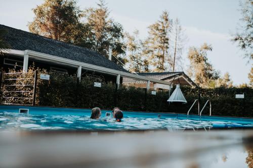 two people are swimming in a swimming pool at Camping Emmen in Schoonebeek