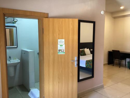 Una puerta a una habitación con cama y baño en Adis Hotels Prime en Ibadán