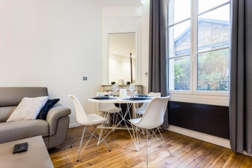 パリにあるAmazing apartment- Eiffel TowerConventionのリビングルーム(テーブル、椅子、ソファ付)