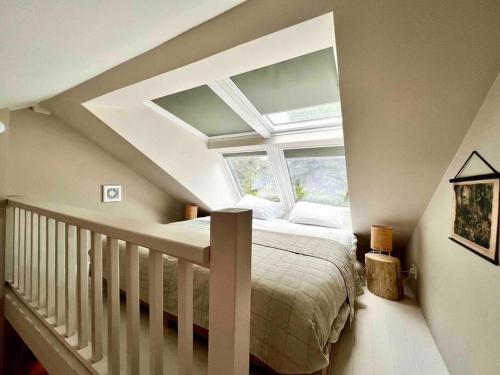 a attic bedroom with a bed and a window at Duynbossie in Schoorl