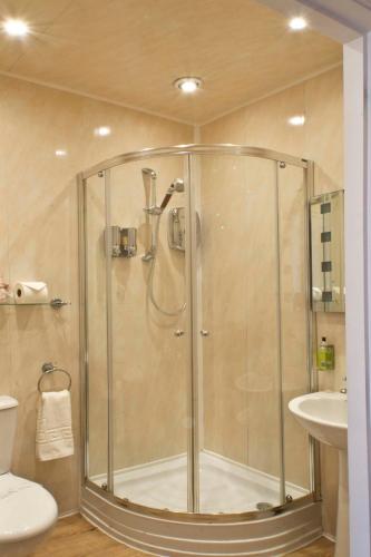 a shower in a bathroom with a toilet and a sink at The Leicester in Southport