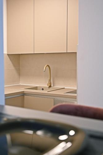 a kitchen with white cabinets and a sink at Hedonist Centar 7 Luxury Apartments in Doboj