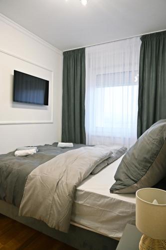 a bedroom with a large bed with a window at Hedonist Centar 7 Luxury Apartments in Doboj