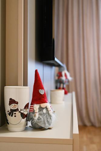 a figurine in a hat sitting next to a coffee cup at Hedonist Centar 7 Luxury Apartments in Doboj