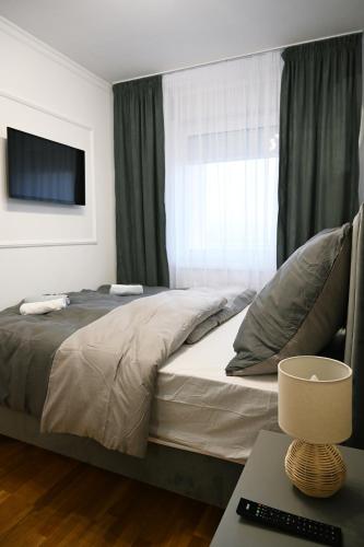 a bedroom with a bed with a television and a table at Hedonist Centar 7 Luxury Apartments in Doboj
