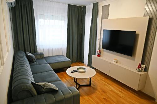 a living room with a couch and a tv at Hedonist Centar 7 Luxury Apartments in Doboj