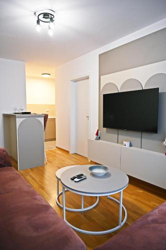 a living room with a table and a tv at Hedonist Centar 7 Luxury Apartments in Doboj