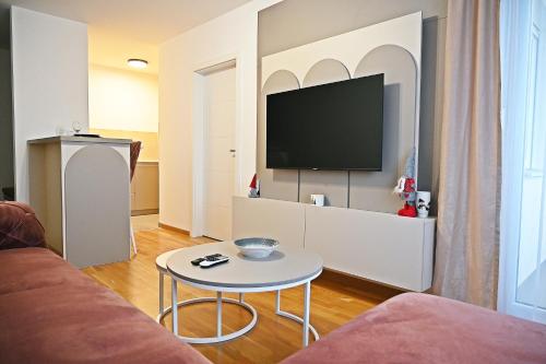 a living room with a couch and a tv at Hedonist Centar 7 Luxury Apartments in Doboj