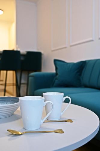 two white cups sitting on a white table at Hedonist Centar 7 Luxury Apartments in Doboj