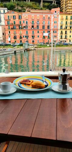 a table with a plate of food and a cup of coffee at Salerno Yacht in Salerno