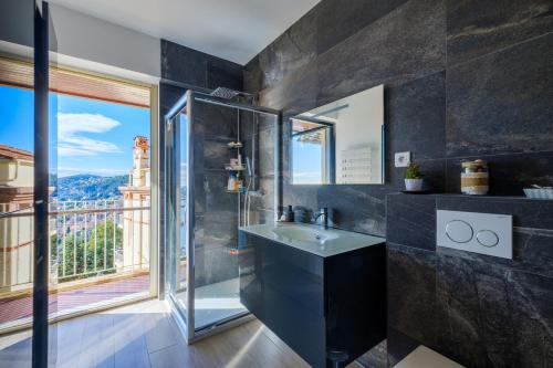 a bathroom with a sink and a large window at Résidence le Clos Charmerade in Villefranche-sur-Mer