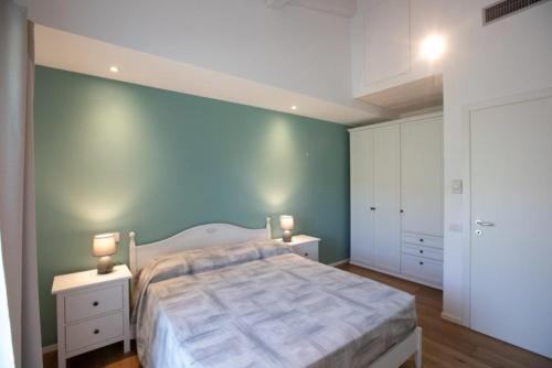 ein Schlafzimmer mit einem großen Bett und zwei Nachttischen in der Unterkunft Appartamento Melograno in Castignano