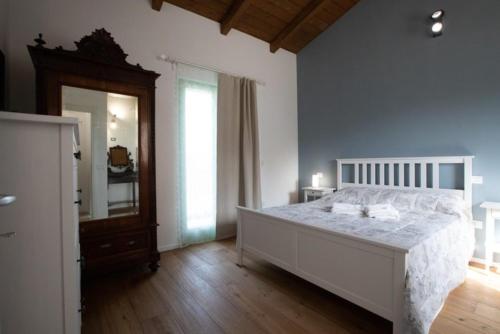 a bedroom with a large bed and a mirror at Depandace Lavanda in Castignano