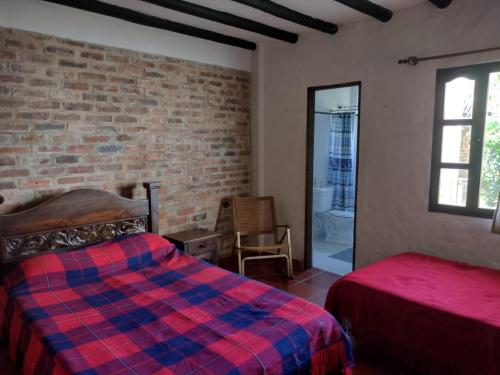 a bedroom with a bed and a brick wall at El Rincon de Quevedo in Sáchica