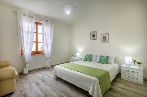 a white bedroom with a bed and a window at Casa Belvedere in Codrongianos